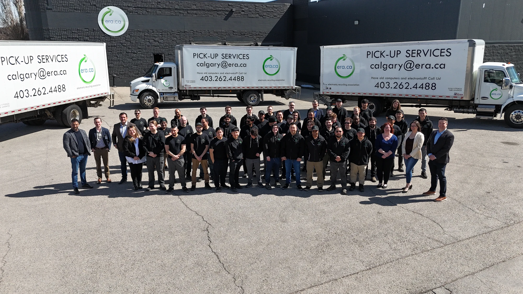 The ERA team in Canada together in the parking lot in front of branded collection trucks
