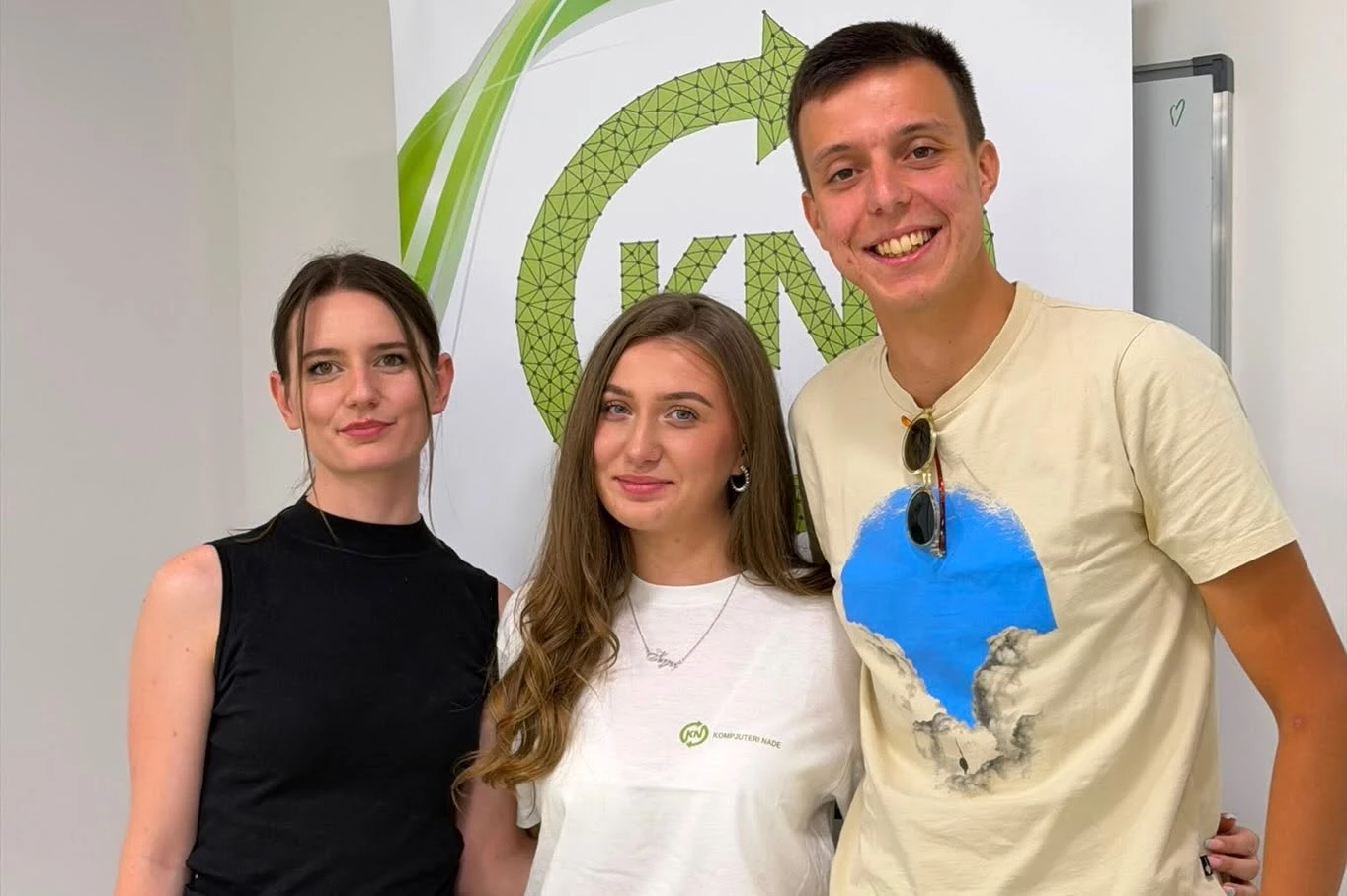The Kompjuteri nade event team beside the KN banner, 2026.